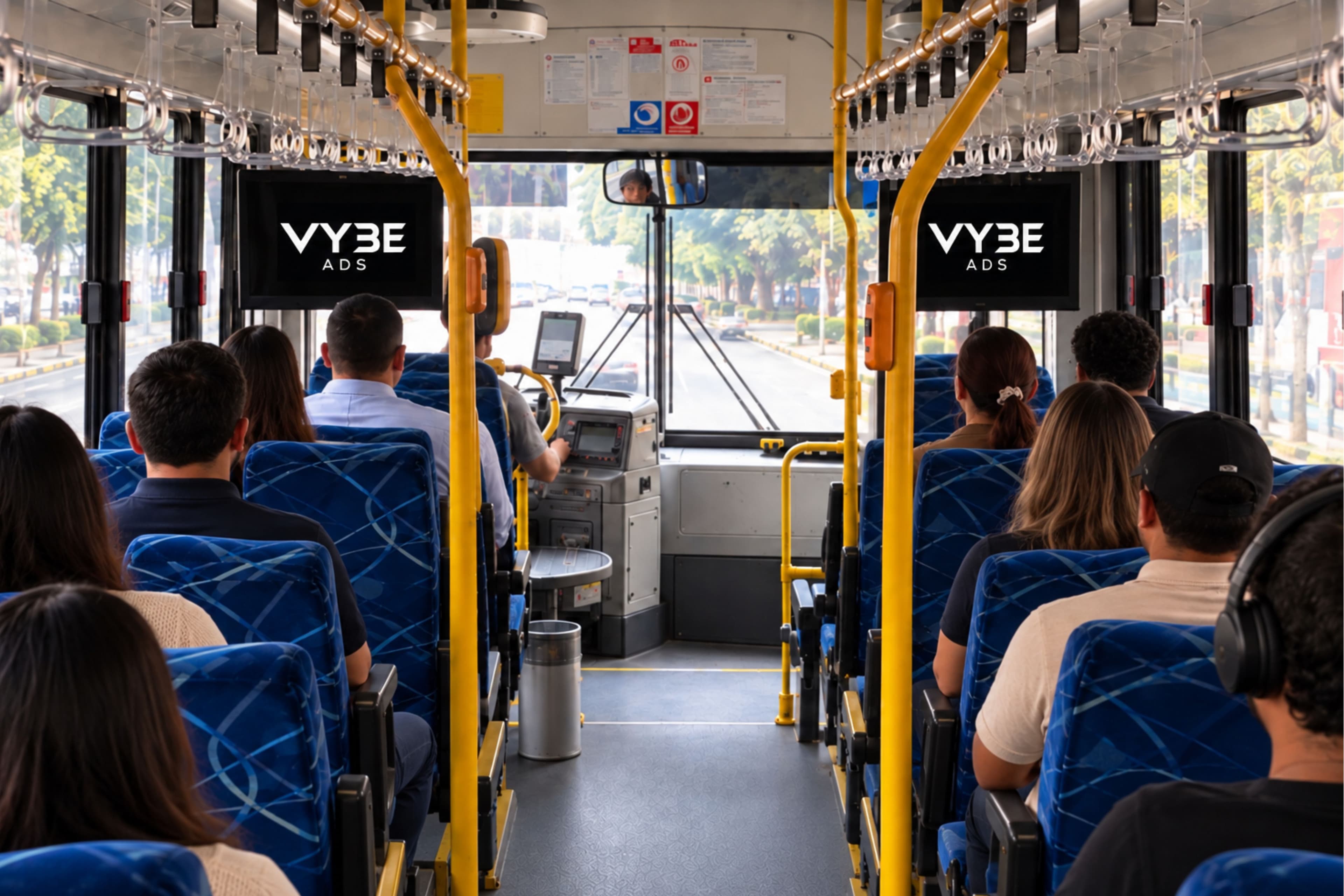 Interior de un autobús con pasajeros sentados y dos pantallas de Vybe Ads sobre el pasillo, visibles para todos los asientos.